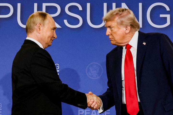 Vladimir Putin y Donald Trump se dan la mano y se miran con intensidad en su reunión en Alaska, el pasado agosto.