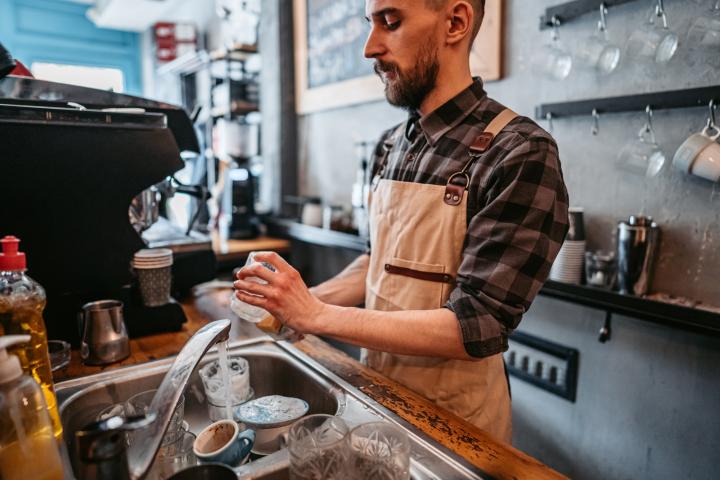 Trabajador-limpia-maquina-cafe