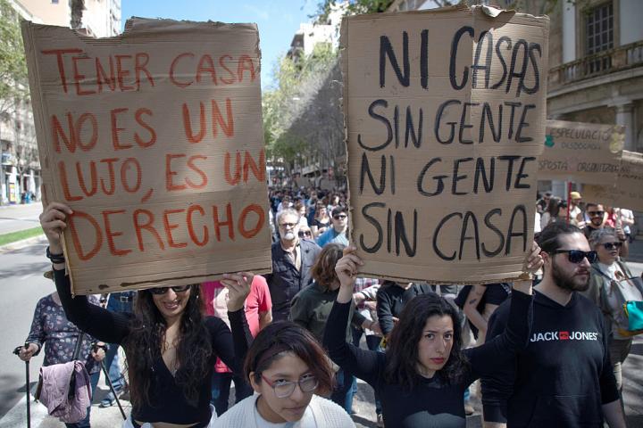 Unos manifestantes portan carteles por el derecho a la vivienda en las calles de Palma.