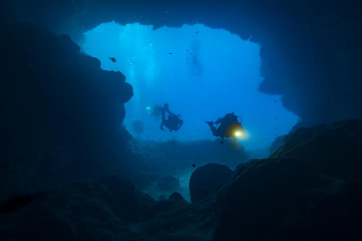 Unos buzos explorando las cuevas de Santa María en el lado norte de la isla de Comino.