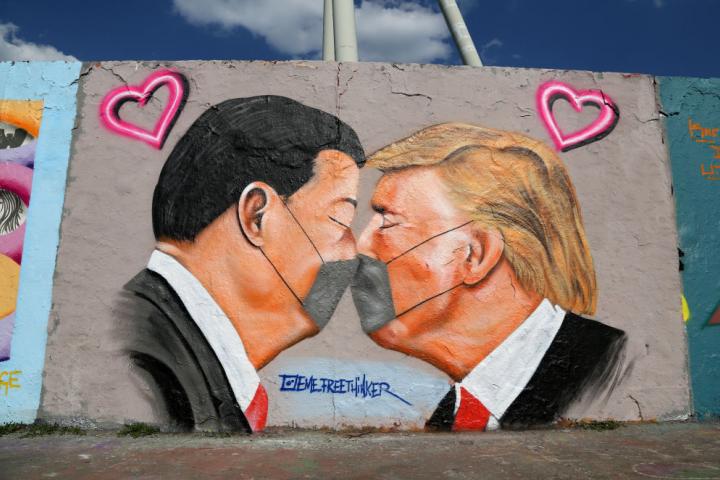 Los presidentes de china, Xi Jinping, y EEUU, Donald Trump, se besan con mascarillas en un grafiti pintado en Berlín.