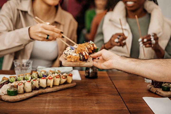 Un grupo de amigos comiendo sushi en un restaurante local.