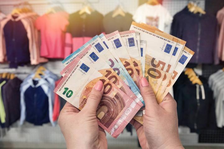 Contando billetes de euro en una tienda ropa