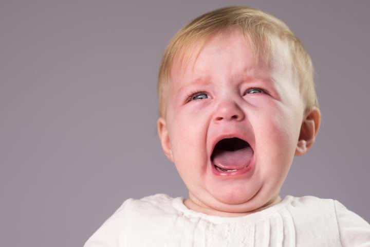 Un bebe rubio, llorando con la cara roja
