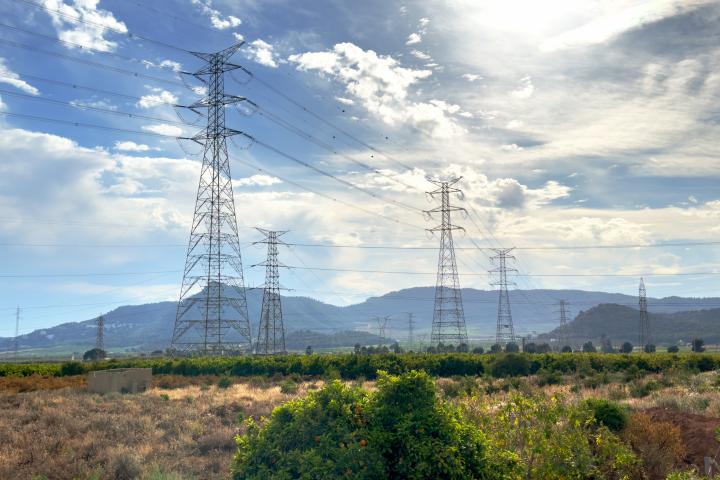 Torres de alta tensión y líneas de transmisión eléctrica en un campo agrícola.
