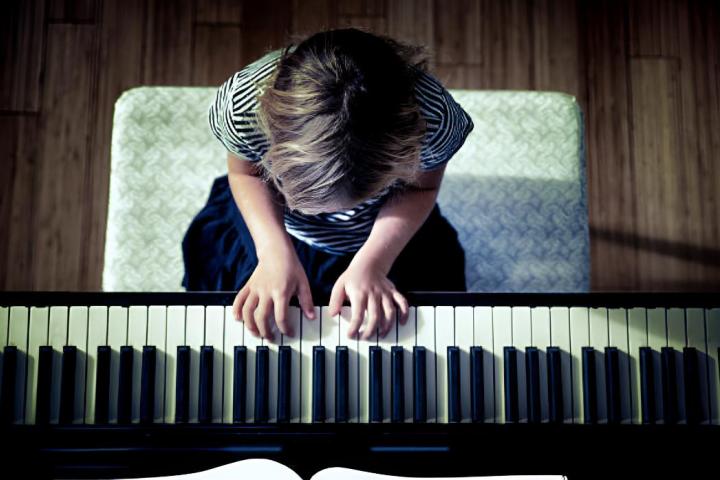 Un plano cenital de una chica tocando el piano