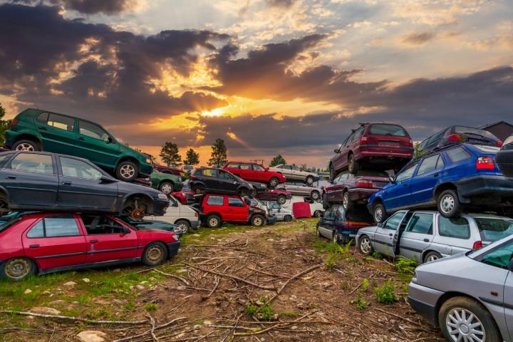 Coches viejos y dañados en el desguace, esperando para ser reciclados