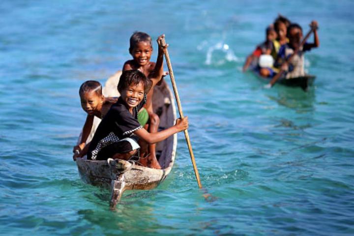 Niños del pueblo bajau en su canoa