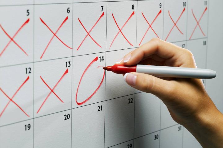 Mujer marcando un día en el calendario de pared, primer plano