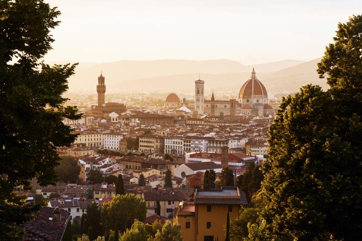 alt="alt="Italia, Toscana, Florencia, horizonte de la ciudad con el Duomo visto a través de los pinos al atardecer""