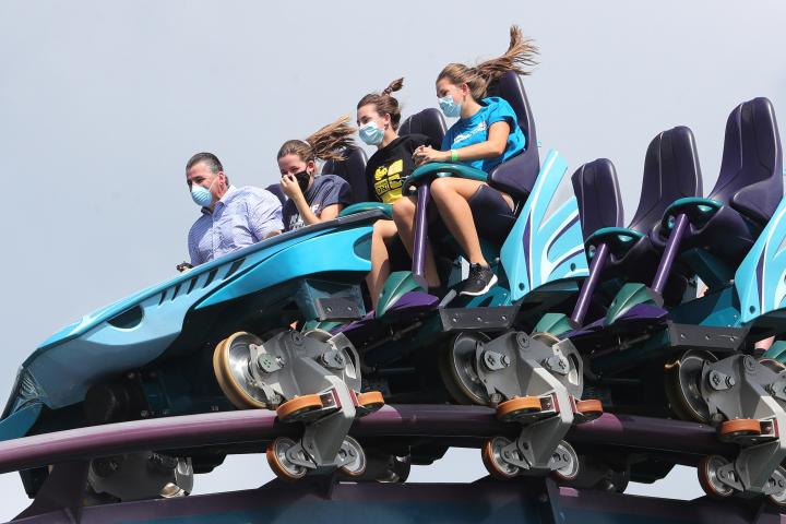 Un grupo de personas disfrutando de la montaña rusa Mako, en Orlando, Florida, durante la época del COVID-19, motivo por el que llevan mascarilla.