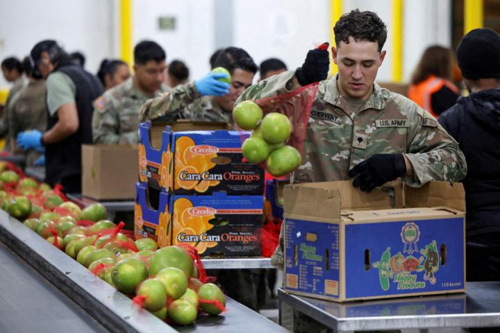 Un miembro de la Guardia Nacional empaca alimentos en cajas en una sede del Banco Regional de Alimentos de Los Ángeles (EEUU), el 29 de octubre de 2025.