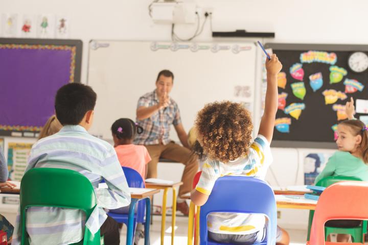 Niño levanta la mano durante una clase de infantil