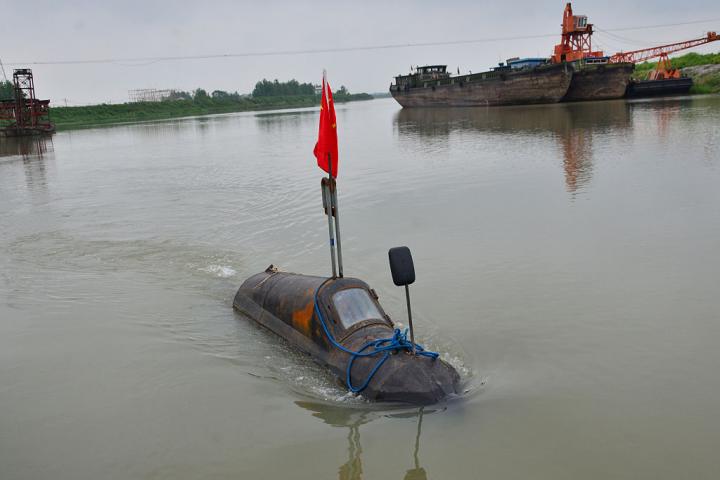 MAANSHAN, CHINA - 27 DE ABRIL: (EXCLUSIVA DE CHINA) Zhang Shengwu conduce su submarino casero en el río, en la aldea de Zhangdu, el 27 de abril de 2016, en Maanshan, provincia de Anhui, China. Zhang Shengwu, de 51 años, quien construyó un muelle y vendió materiales de construcción, invirtió más de 5000 yuanes (unos 771 USD) en la construcción de un submarino en dos meses en Maanshan. El submarino, de 6 metros de largo y 2 toneladas, funciona con un motor de triciclo y carece de sistema de suministro de oxígeno. Puede sumergirse a más de un metro de profundidad y Zhang obtuvo la patente nacional en febrero de 2016. (Foto de Ma Fengcheng/VCG)