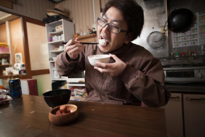 Hombre japonés comiendo arroz