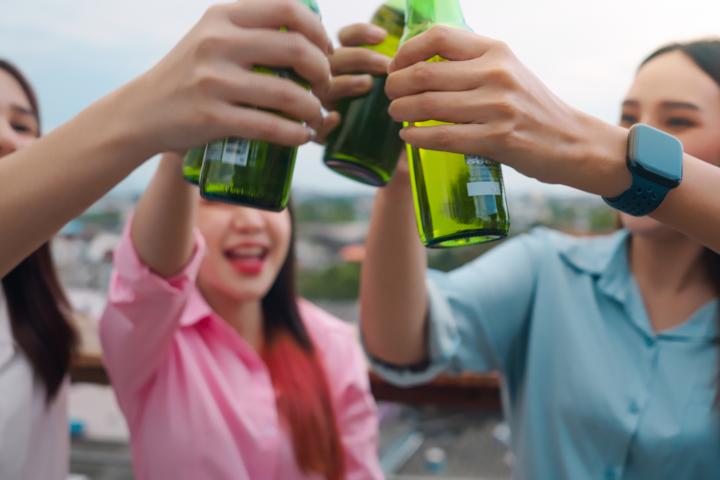 Jóvenes brindando y bebiendo en grupo.