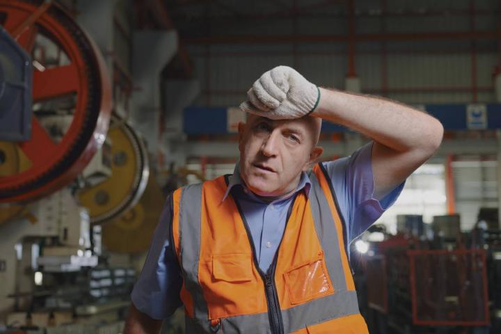 Cansado y acalorado en la línea de producción de la fábrica