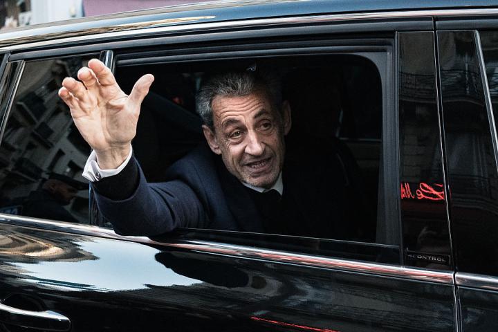 El expresidente francés Nicolas Sarkozy saluda con el dedo en alto a través de la ventanilla a sus seguidores de camino a su ingreso en la cárcel, el 21 de octubre de 2025, en París.