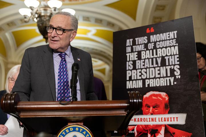 El líder de la minoría demócrata del Senado, Chuck Schumer, atiende a la prensa desde un atril, rodeado de carteles contra Donald Trump, el 28 de octubre de 2025.