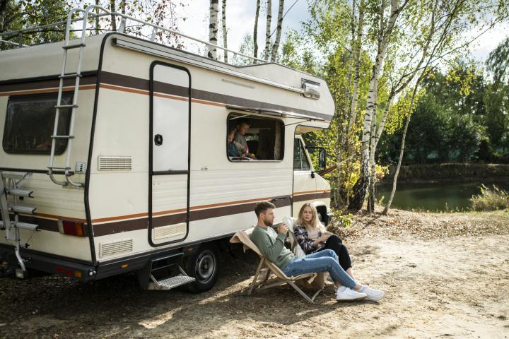 Familia relajándose en una autocaravana en un camping.