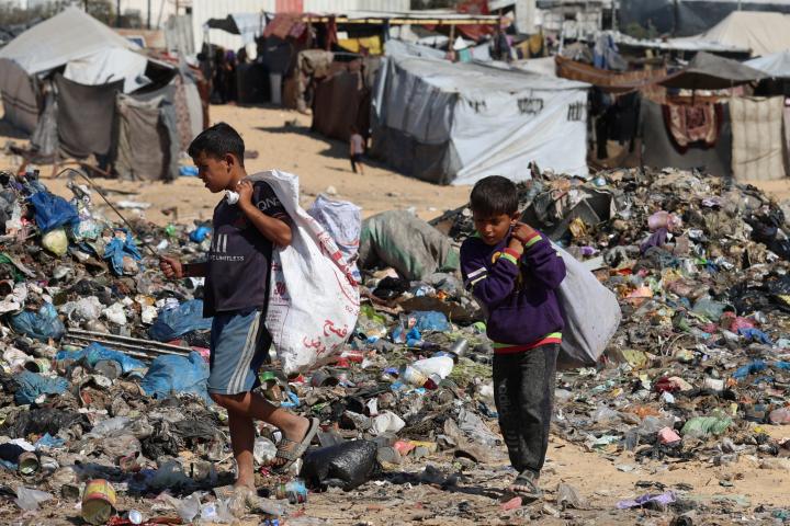 Niños palestinos rebuscan entre la basura cerca de un vertedero en Jan Yunis, al sur de la Franja de Gaza, el 30 de octubre de 2025.