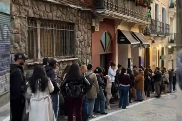 Decenas de personas haciendo cola en un local de Madrid.