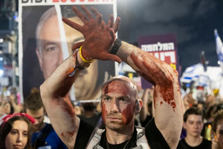 Un manifestante, con 'sangre' en la caraº