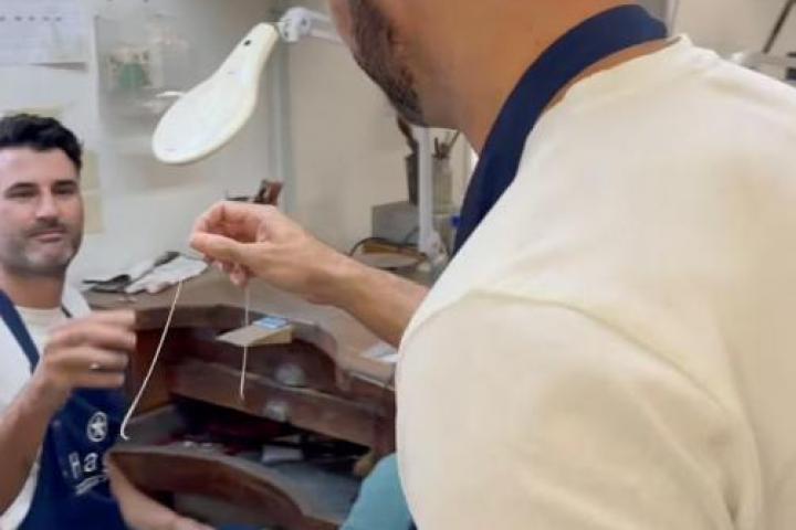 Un joyero arreglando el nudo de una cadena.