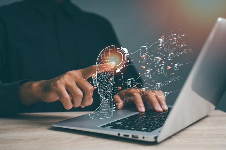 Una persona usa un ordenador portátil para dibujar un cerebro con inteligencia artificial.