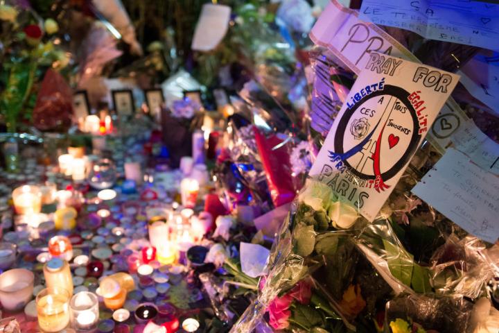Velas encendidas, flores y banderas en un altar improvisado frente a la sala de conciertos Bataclan en París, el 15 de noviembre de 2015, tras los atentados yihadistas.
