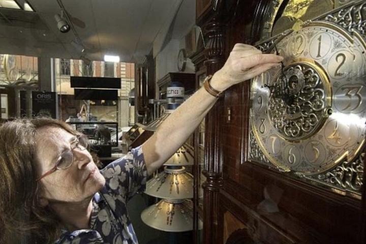 Una mujer cambiando la hora en un reloj suizo