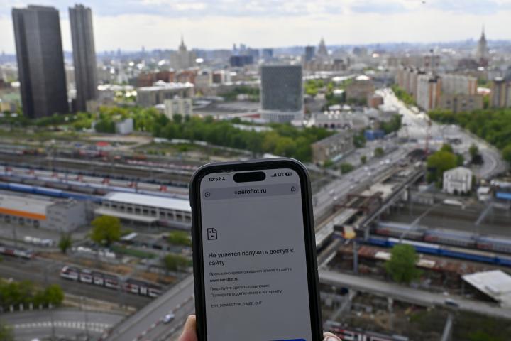 Pantalla de un teléfono móvil que muestra problemas para acceder a Internet móvil con la ciudad de Moscú en el fondo.