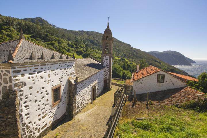 Vista de la famosa iglesia de San Andrés de Teixido en Galicia, España. La iglesia fue construida entre los siglos XVI y XVIII. Este templo es uno de los lugares de peregrinación más importantes de Galicia. Está situado en un lugar espectacular junto al mar y rodeado por una magnífica sucesión de acantilados y las estribaciones de la Serra da Capelada.
