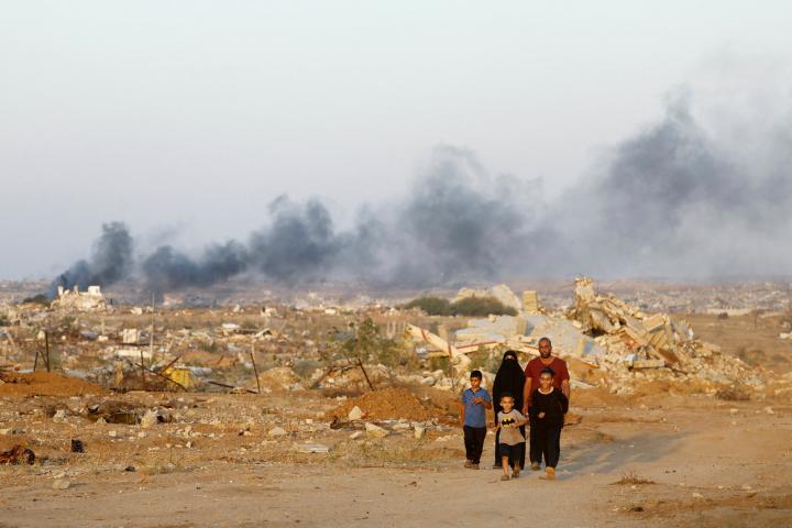 Una familia palestina camina entre los escombros de edificios destruidos en Nuseirat, en el centro de la franja de Gaza, 31 de octubre de 2025.