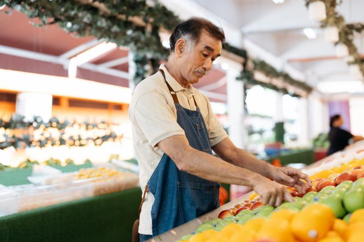 Una persona mayor trabajando en un supermercado.