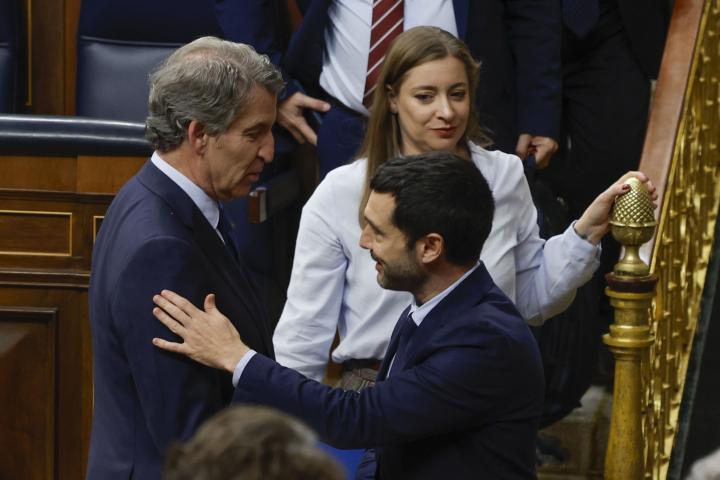 El líder del PP, Alberto Núñez Feijóo (i) saluda al ministro de Derechos Sociales, Consumo y Agenda 2030, Pablo Bustinduy durante el pleno del Congreso de este miércoles.