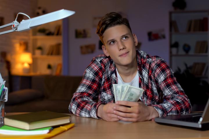 Imagen de un joven contando billetes.