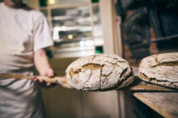 Un trabajador de una panadería saca pan