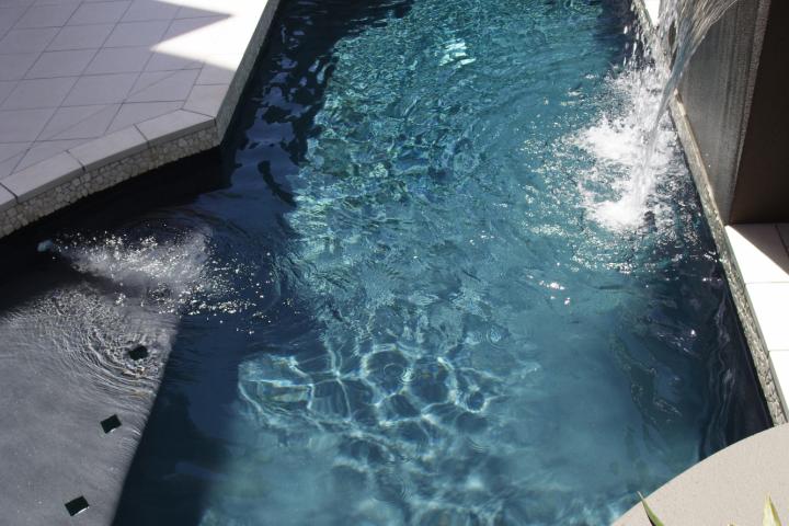 alt="alt="El agua cae en cascada a la piscina""