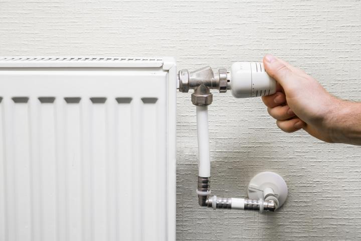 Imagen de una persona ajustando la temperatura de la calefacción.