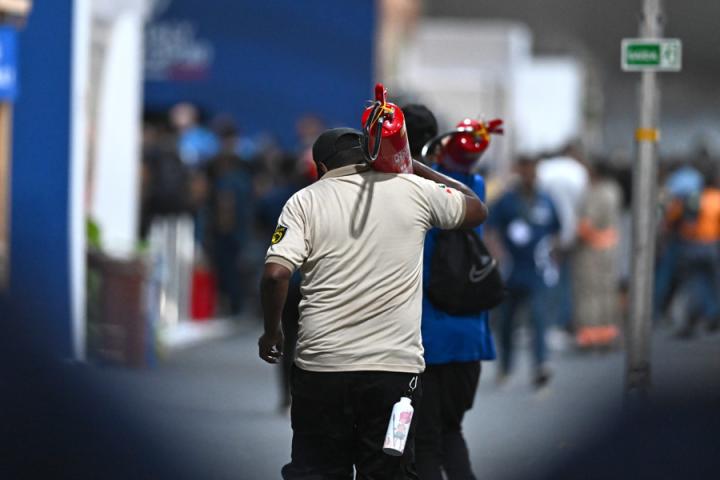 Operarios de seguridad trabajan para apagar el fuego declarado este jueves dentro de la Cumbre del Clima