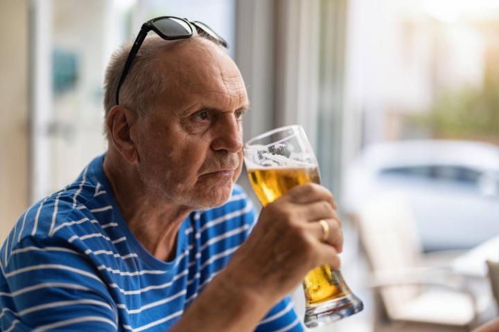 Hombre mayor tomando cerveza enfadado