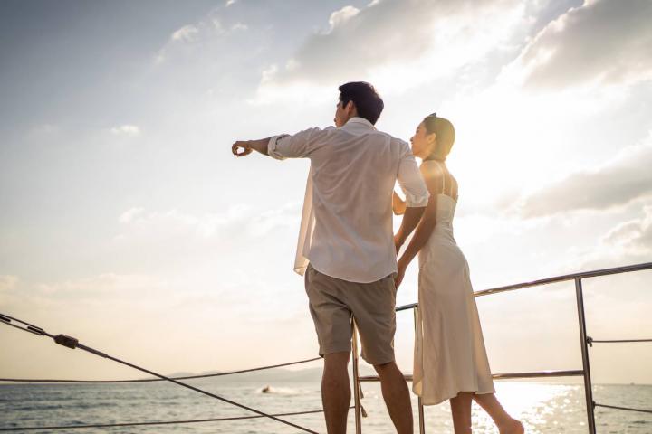 Pareja bebiendo champán mientras se va de fiesta en yate