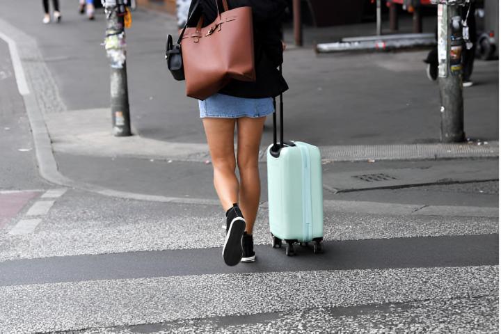Una mujer caminando con una maleta por la calle