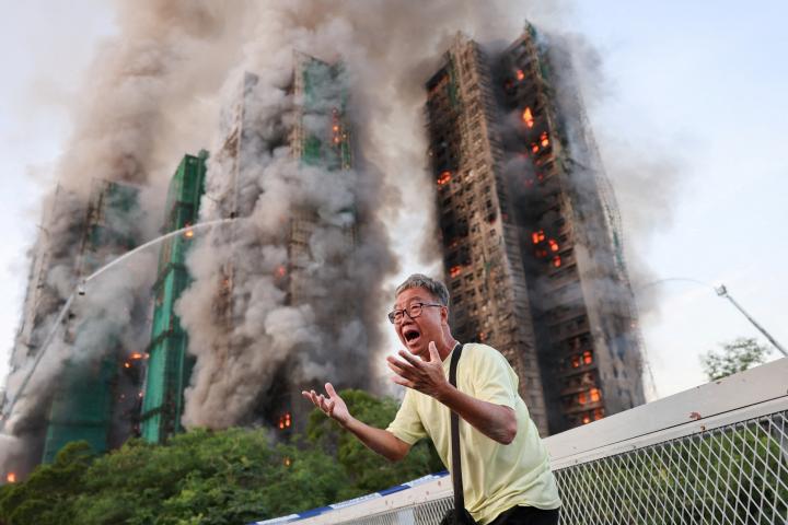 Un hombre grita mientras el humo se eleva en varios edificios en el complejo residencial Wang Fuk Court, en Tai Po (Hong Kong, China), el 26 de noviembre de 2025.