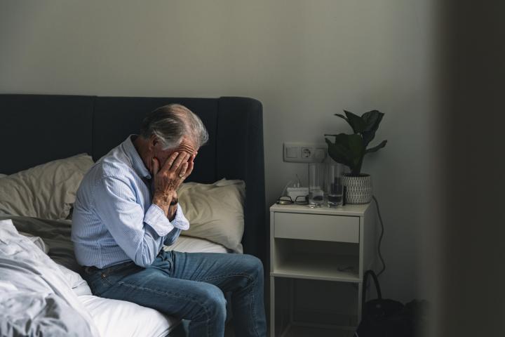 Un jubilado, con las manos en la cara, representando lamentación o preocupación