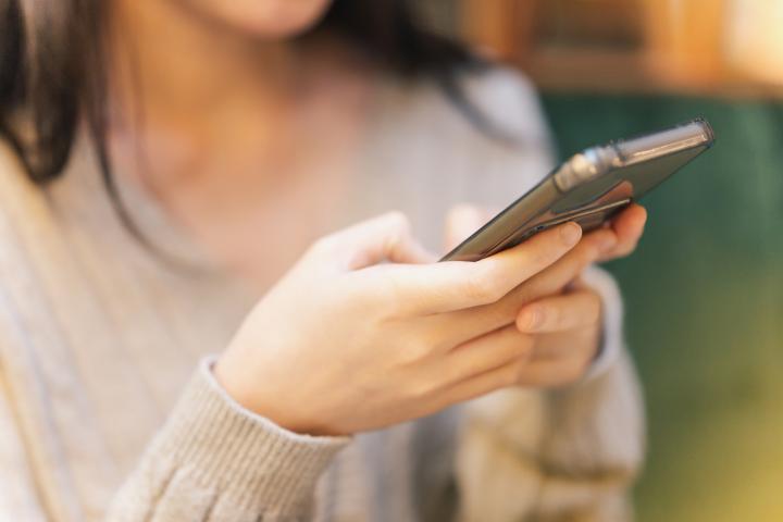 Una mujer usando la IA en su teléfono móvil.
