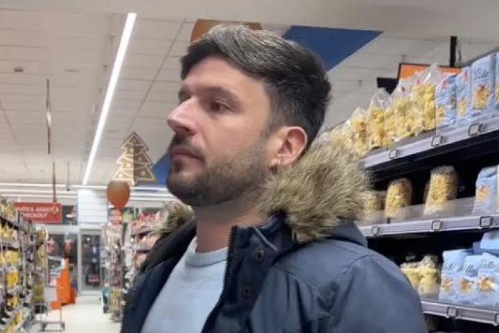 Novio español en un supermercado italiano mirando distintos tipos de pasta mientras su pareja graba.