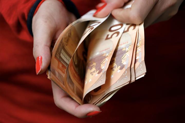 Una mujer contando billetes de 50 euros