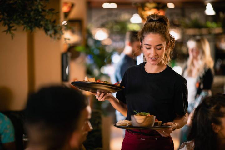 Una camarera sirviendo comida a los clientes en un restaurante de Newcastle upon Tyne